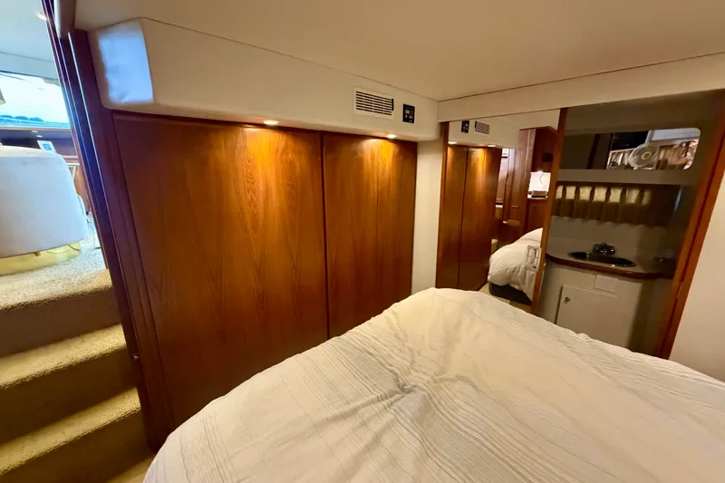 Slide: The Image of 1994 Carver 440 Aft Cabin Motor Yacht interior with wood paneling and cozy bedroom. - 26