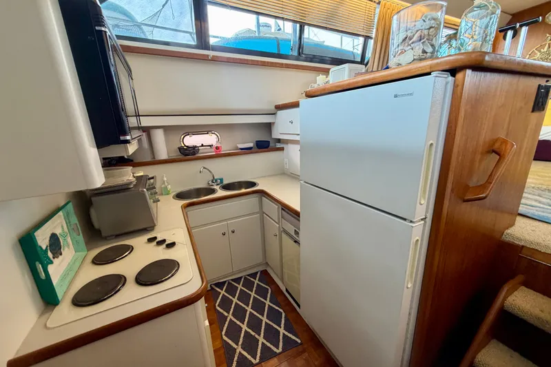 Slide: The Image of Compact kitchen in a 1994 Carver 440 Aft Cabin Motor Yacht with stove, sink, and refrigerator. - 18