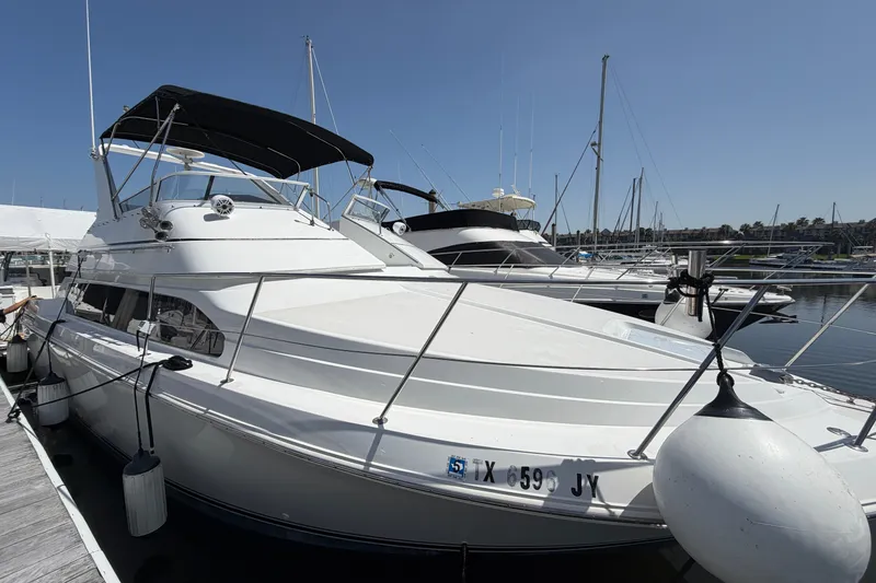 The Image of 2001 Carver 380 Santego SE yacht docked at marina under clear blue sky. - 0