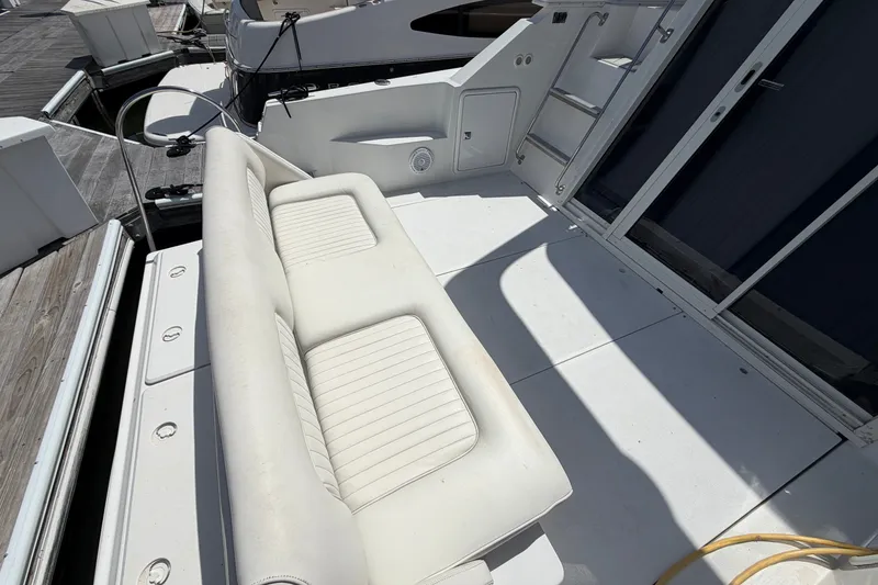 Slide: The Image of 2001 Carver 380 Santego SE yacht deck with white seating and dock view. - 7