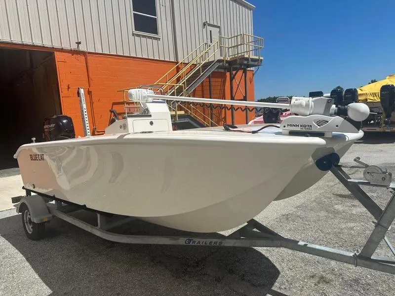 Slide: The Image of 2024 BlueCat 17 boat on trailer outside industrial building. - 1