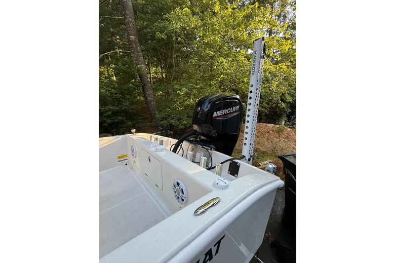 Slide: The Image of 2024 BlueCat 17 boat with Mercury engine, set in a wooded area. - 7