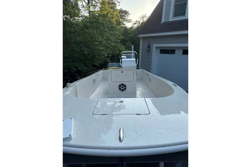 Slide: The Image of 2024 BlueCat 17 boat parked near a garage, surrounded by trees. - 4