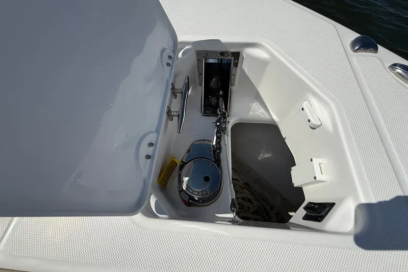Slide: The Image of Anchor compartment of 2022 Everglades 273 Center Console boat, featuring a secure chain mechanism. - 32