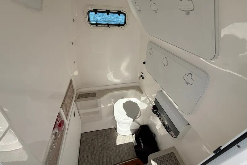 Slide: The Image of Interior of 2022 Everglades 273 Center Console boat, featuring storage compartments and a small window. - 25