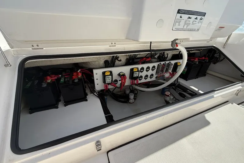 Slide: The Image of Electrical compartment of 2022 Everglades 273 Center Console boat, showing batteries and wiring. - 12
