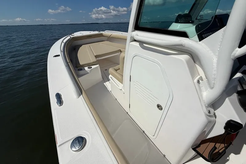 Slide: The Image of 2022 Everglades 273 Center Console boat on calm water, showcasing seating and console. - 23