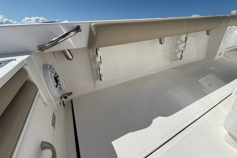 Slide: The Image of 2022 Everglades 273 Center Console boat interior with cushioned seating and stainless steel fixtures. - 16