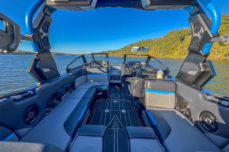 Slide: The Image of 2024 Supra SV 400 boat interior with sleek design on a scenic lake. - 26