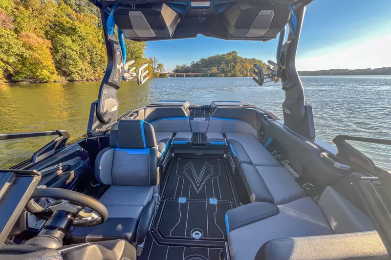 Slide: The Image of 2024 Supra SV 400 boat interior with luxurious seating on a scenic lake. - 32