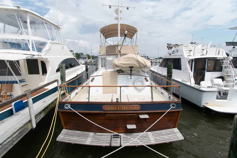 Slide: The Image of 1974 Grand Banks 42 Classic yacht docked at marina, surrounded by other boats. - 2