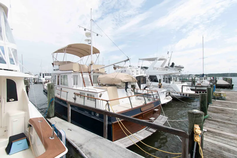 Slide: The Image of 1974 Grand Banks 42 Classic yacht docked at a marina under a cloudy sky. - 1