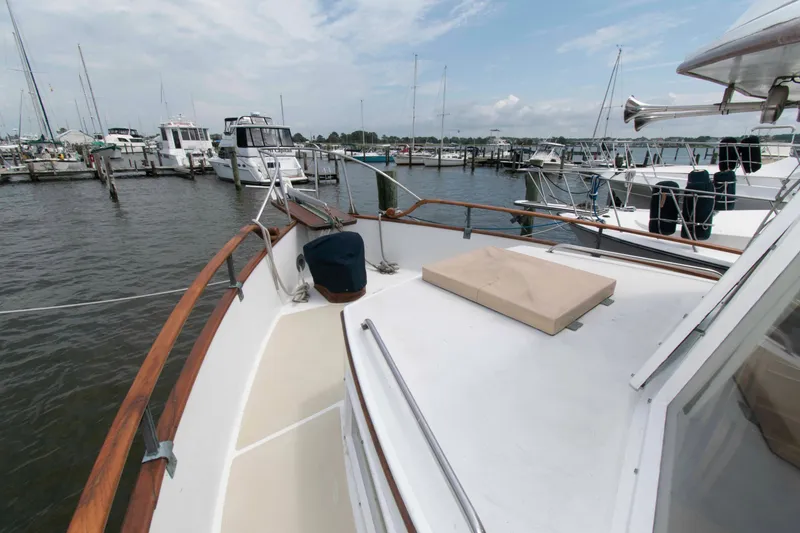 Slide: The Image of 1974 Grand Banks 42 Classic yacht docked at a marina, showcasing its spacious deck. - 4