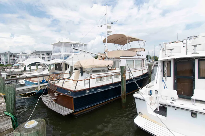 The Image of 1974 Grand Banks 42 Classic yacht docked at a marina under a cloudy sky. - 0