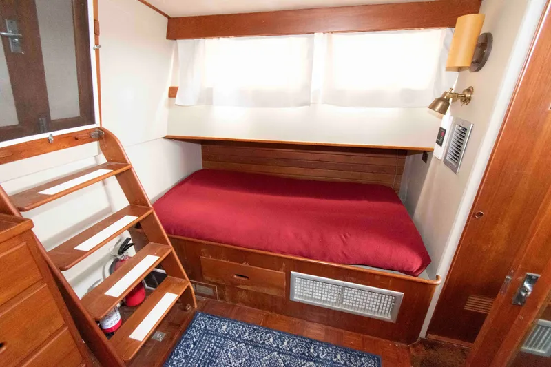 Slide: The Image of Cozy cabin interior of 1974 Grand Banks 42 Classic with red bedding and wooden accents. - 25