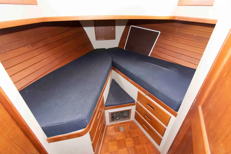 Slide: The Image of 1974 Grand Banks 42 Classic cabin interior with wooden paneling and blue cushions. - 27