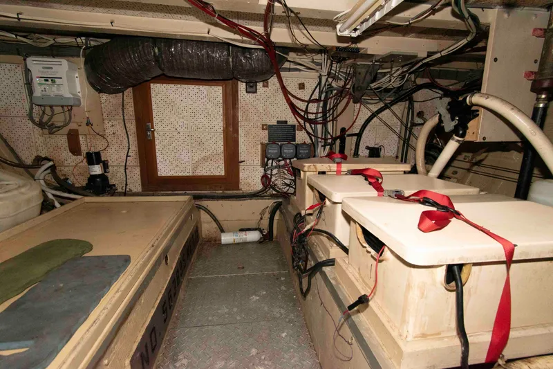 Slide: The Image of Engine room of a 1974 Grand Banks 42 Classic boat, featuring batteries and wiring. - 30