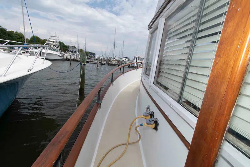 Slide: The Image of 1974 Grand Banks 42 Classic yacht docked at marina, showcasing wooden railings and windows. - 3