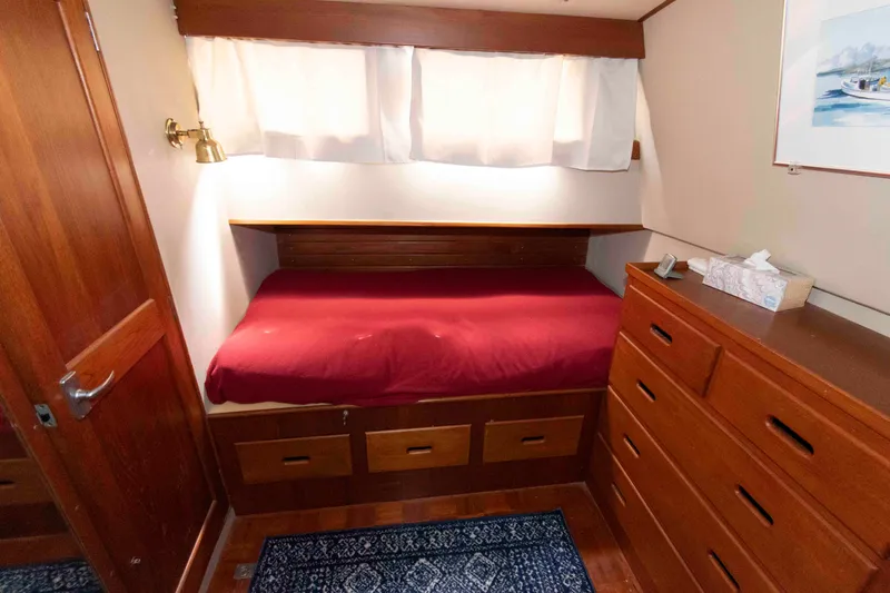 Slide: The Image of Cozy cabin interior of 1974 Grand Banks 42 Classic with wooden furnishings and red bedding. - 24
