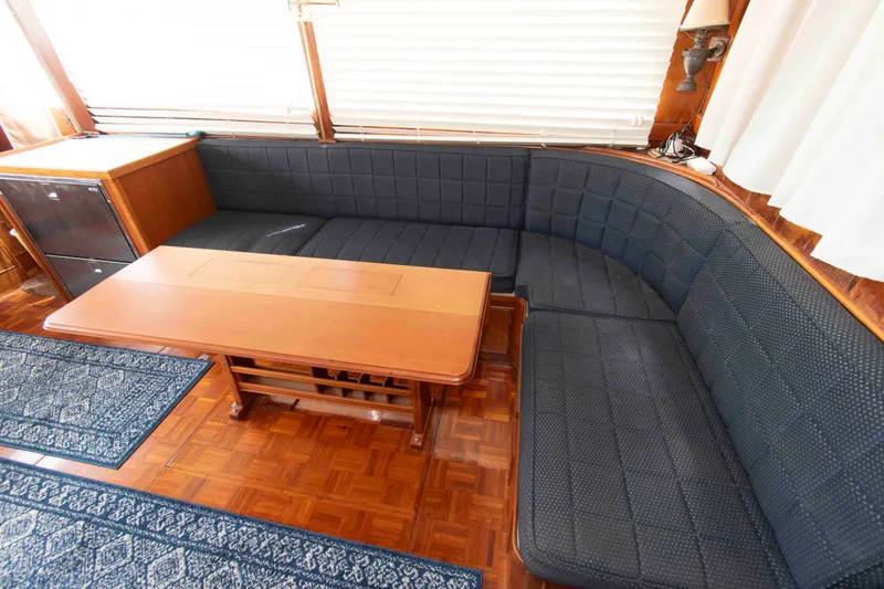 Slide: The Image of Interior of 1974 Grand Banks 42 Classic yacht with wooden table and blue cushioned seating. - 16
