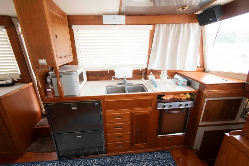 Slide: The Image of 1974 Grand Banks 42 Classic yacht kitchen with wooden cabinetry, sink, and appliances. - 18