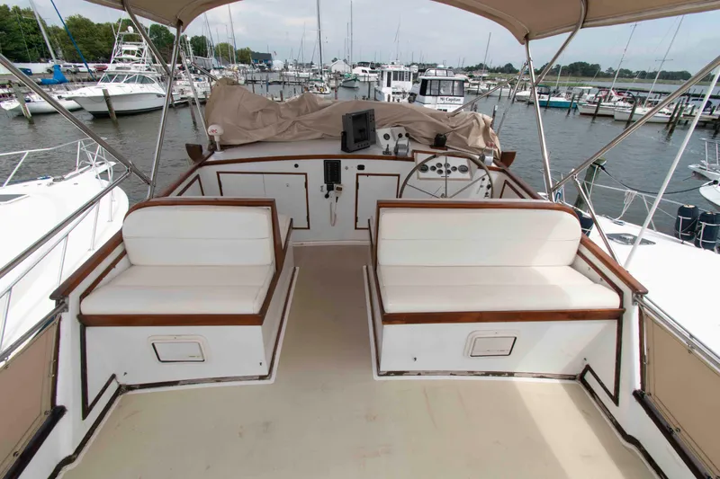 Slide: The Image of 1974 Grand Banks 42 Classic yacht helm with seating, docked in a marina. - 8