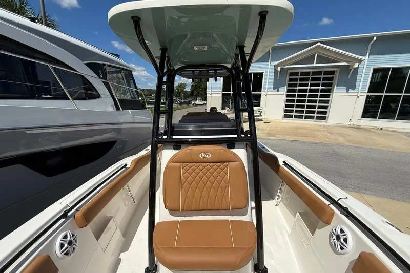 Slide: The Image of 2027 Key West 239 FS boat interior with tan seating and black T-top under blue sky. - 4