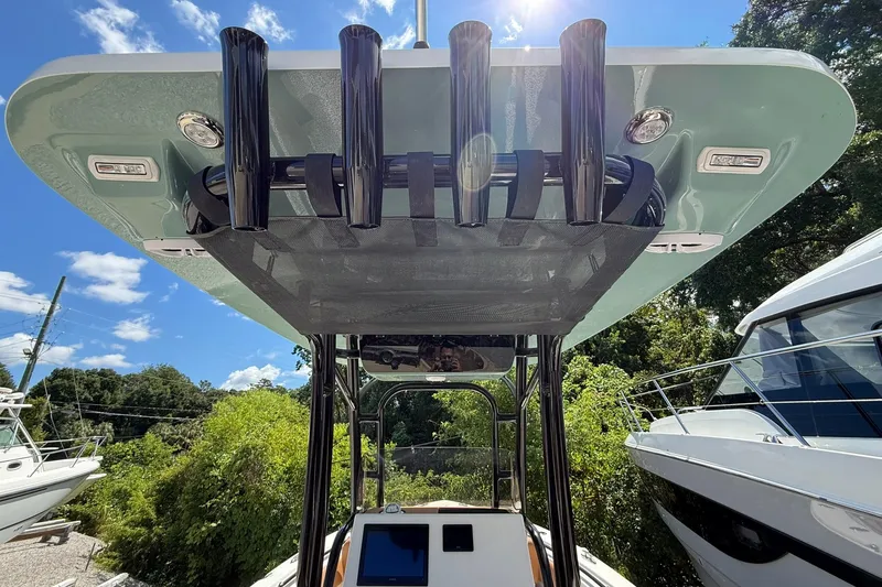 Slide: The Image of 2027 Key West 239 FS boat with T-top and rod holders, parked outdoors. - 7