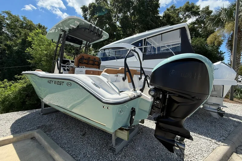 Slide: The Image of 2027 Key West 239 FS boat with Yamaha engine, displayed outdoors on gravel. - 2