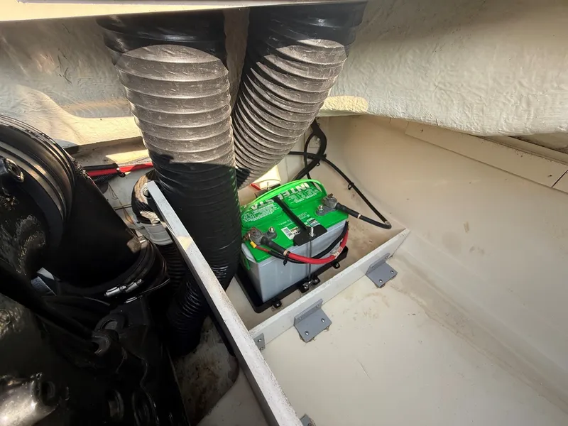 Slide: The Image of View of a 2006 Sea Ray 185 Sport engine compartment with a battery and hoses. - 22