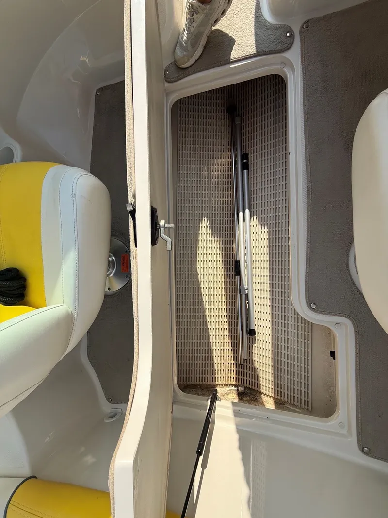 Slide: The Image of An open storage compartment on a boat with yellow and white seats. - 24