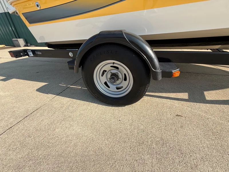 Slide: The Image of Close-up of a boat trailer with a black wheel and a yellow boat on it. - 26