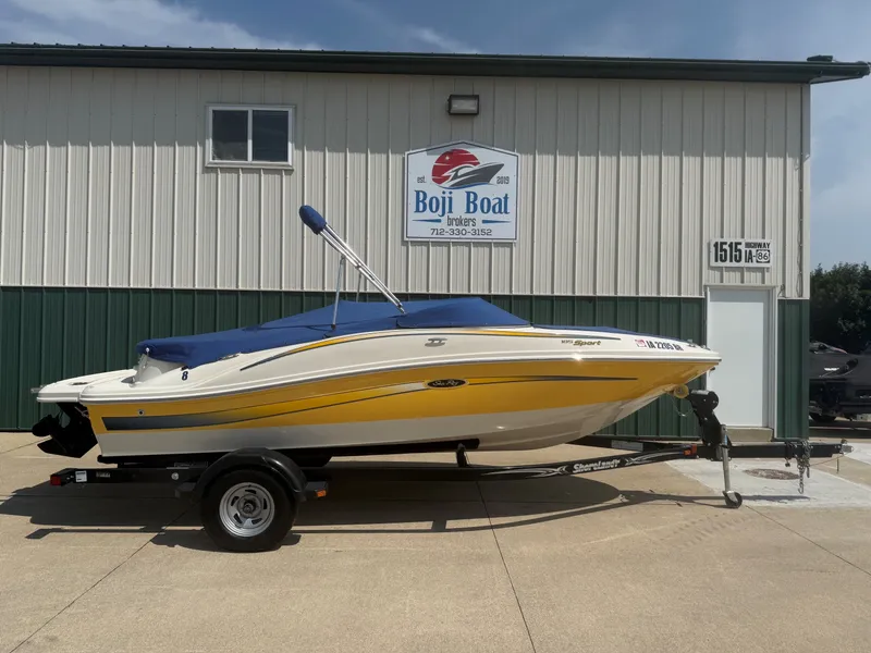 Slide: The Image of A 2006 Sea Ray 185 Sport boat on a trailer in front of a building. - 29