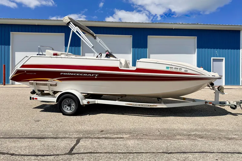 Slide: The Image of 2005 Princecraft Vacanza 210V O/B boat on trailer, parked outside blue building. - 6
