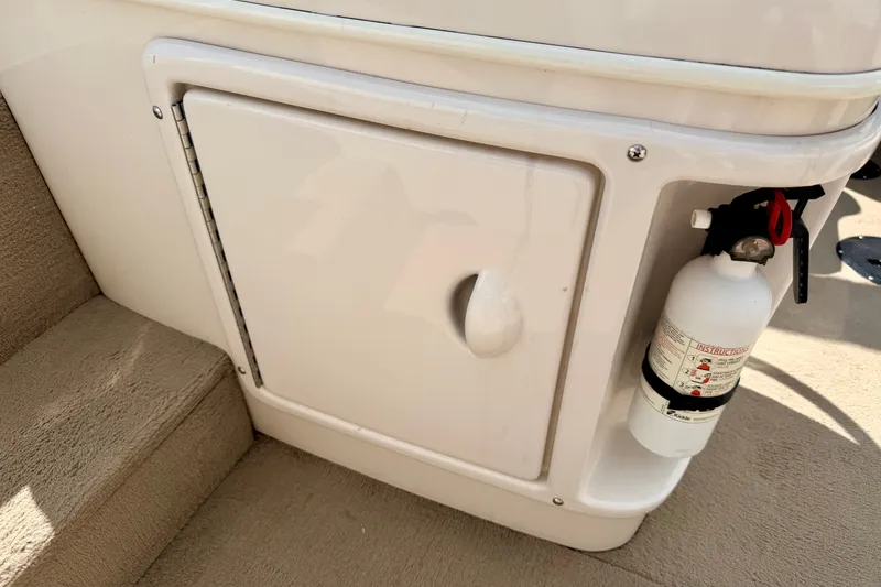Slide: The Image of 2005 Princecraft Vacanza 210V O/B boat interior with storage compartment and fire extinguisher. - 56