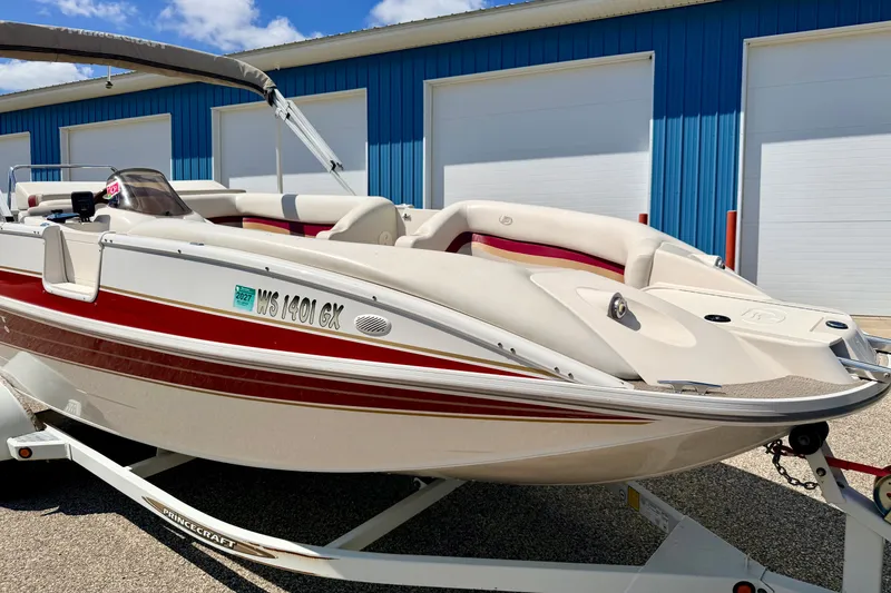 Slide: The Image of 2005 Princecraft Vacanza 210V O/B boat on trailer, parked near blue building. - 11