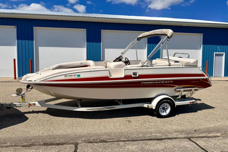 Slide: The Image of 2005 Princecraft Vacanza 210V O/B boat on trailer, parked near blue building. - 7