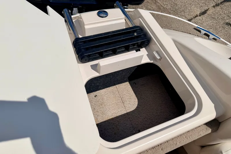 Slide: The Image of 2005 Princecraft Vacanza 210V O/B boat storage compartment with ladder, open and sunlit. - 50
