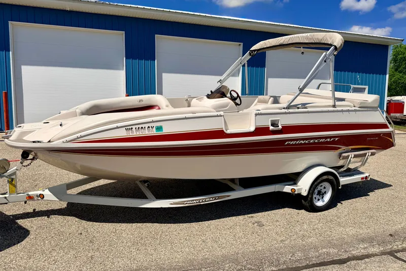 Slide: The Image of 2005 Princecraft Vacanza 210V O/B boat on trailer, parked near blue building. - 5