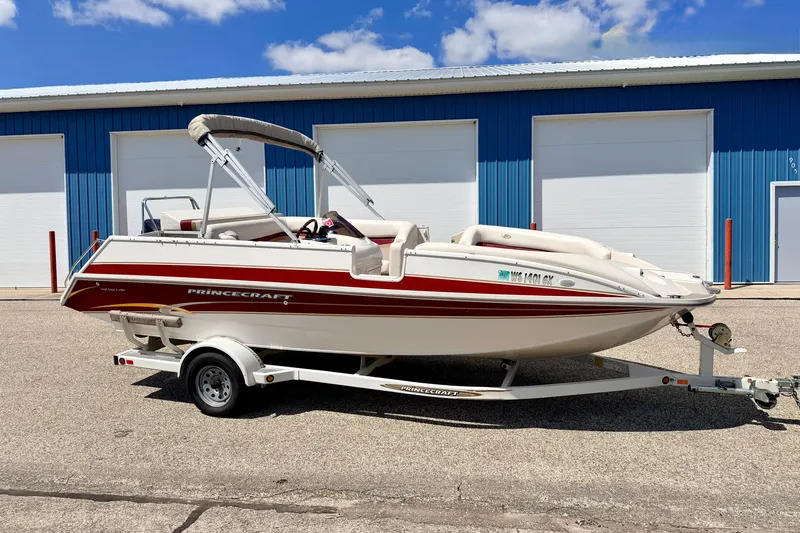 Slide: The Image of 2005 Princecraft Vacanza 210V O/B boat on trailer, parked near blue building. - 4