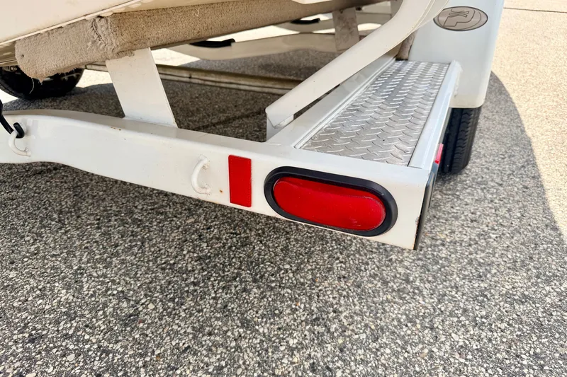 Slide: The Image of Trailer detail of a 2005 Princecraft Vacanza 210V O/B, featuring red reflector and step. - 72