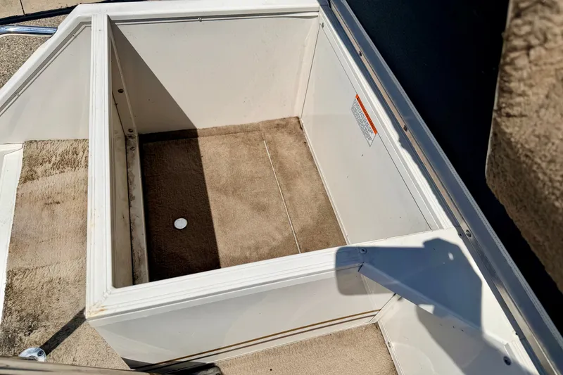 Slide: The Image of Open storage compartment on 2005 Princecraft Vacanza 210V O/B boat, featuring carpeted interior. - 25