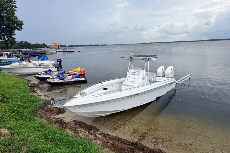 The Image of 2018 Glasstream 280 Pro-XS boat docked by a lakeside with jet skis nearby. - 5
