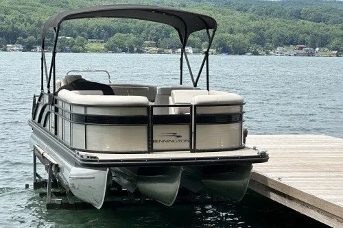 Slide: The Image of 2017 Bennington 24SSBXP pontoon boat docked on a scenic lake. - 4