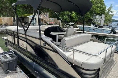 Slide: The Image of 2017 Bennington 24SSBXP pontoon boat docked, featuring spacious seating and canopy. - 5