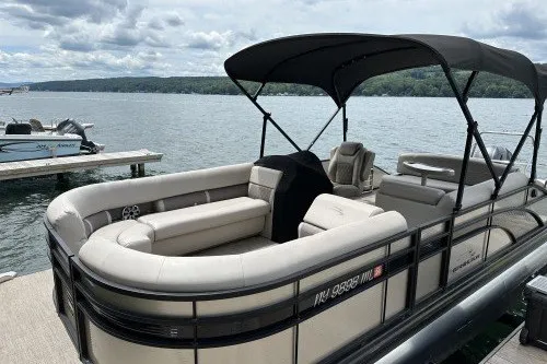 Slide: The Image of 2017 Bennington 24SSBXP pontoon boat docked by a scenic lake under cloudy skies. - 3