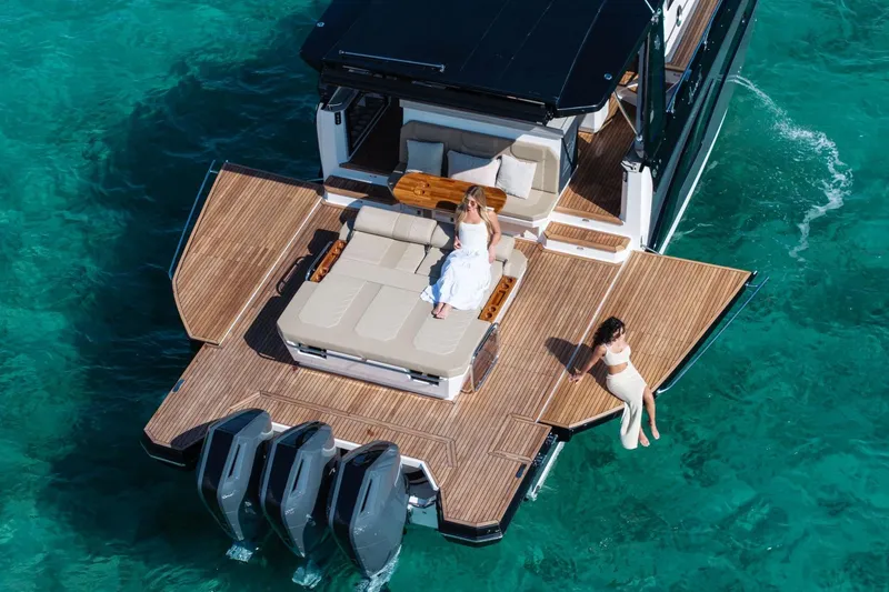Slide: The Image of Luxury Hanover 447 yacht, 2026 model, with two people relaxing on deck in turquoise waters. - 19