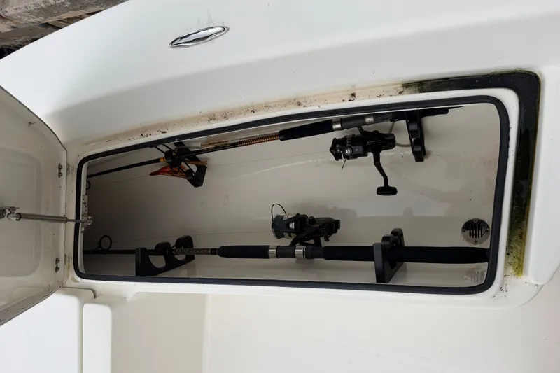 Slide: The Image of Open storage compartment with fishing rods in a 2015 Pathfinder 2200 V Tournament Edition boat. - 11