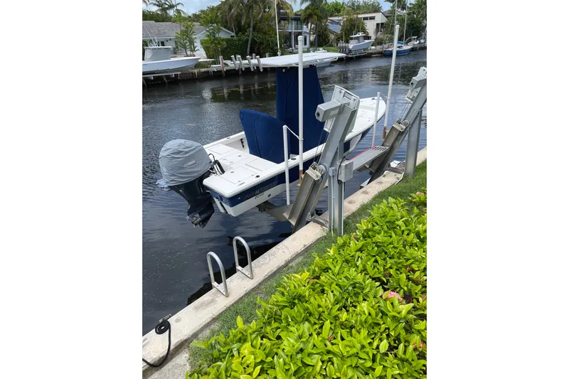 Slide: The Image of 2015 Pathfinder 2200 V Tournament Edition boat docked by a canal with lush greenery. - 4