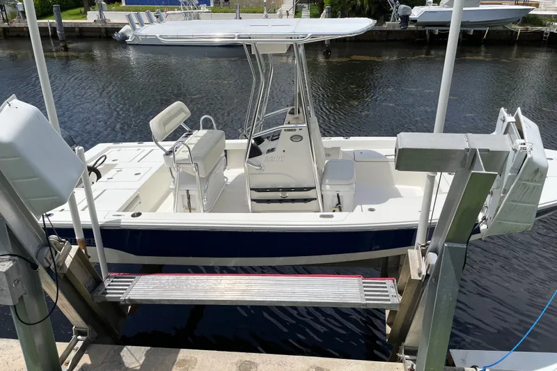 Slide: The Image of 2015 Pathfinder 2200 V Tournament Edition boat docked on a lift by the water. - 2